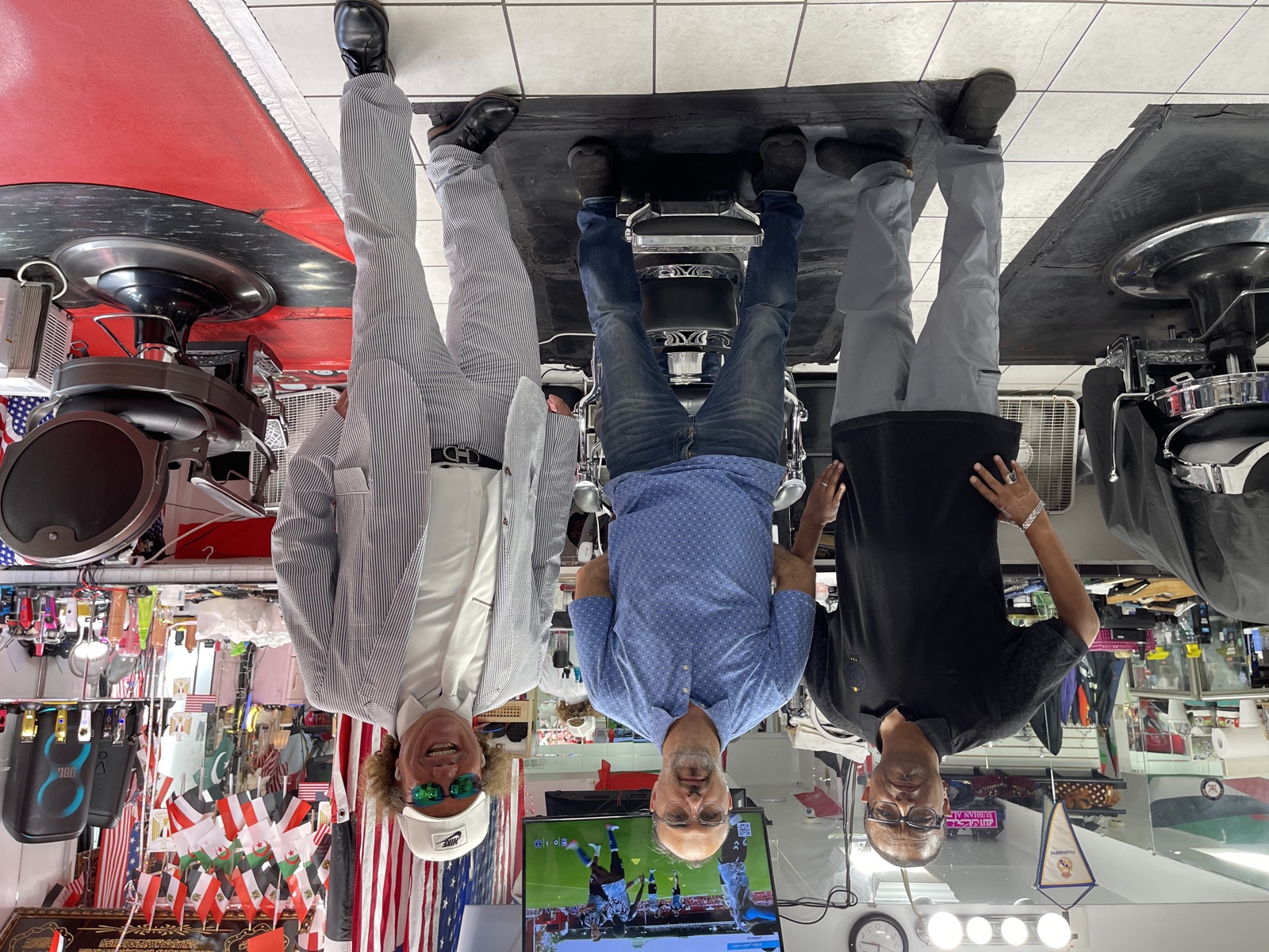 Three of the Makkah Barber Shop barbers together on the shop floor