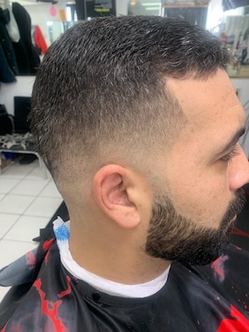 A low fade blended into a sharp, full beard